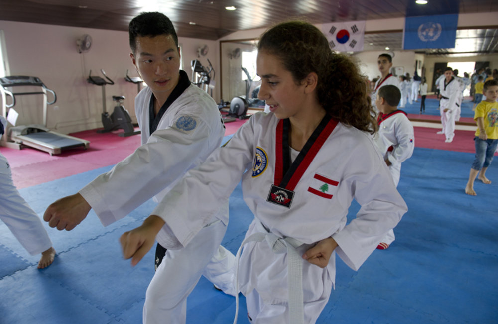 Korean peacekeeper is teaching one female student self-defense in Taekwondo classes.