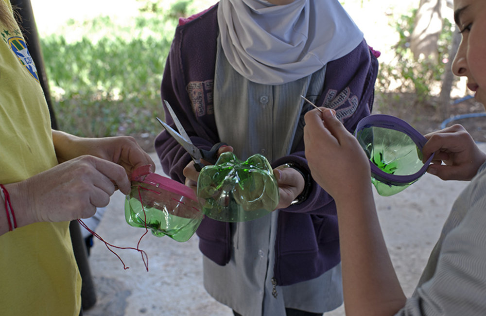 Two girls from Tyre public schools learning how to make art craft with plastic trash.