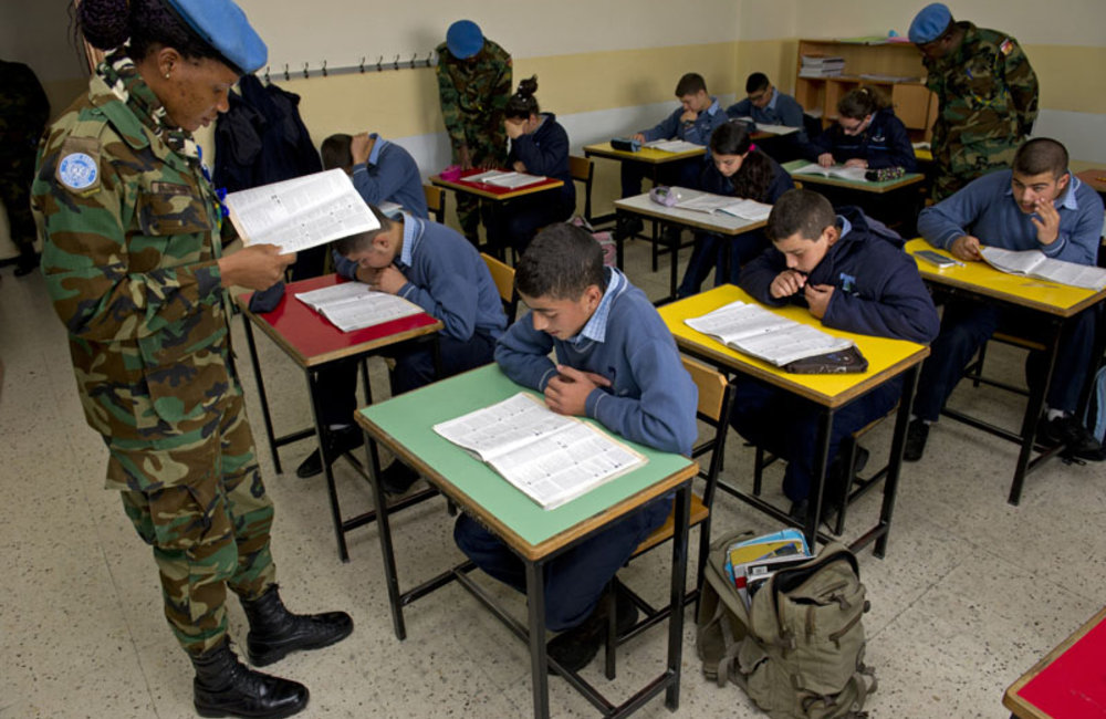 UNIFIL’s Ghanaian battalion Corporal Akorpa Edzorhoho reading with the students of her English class.