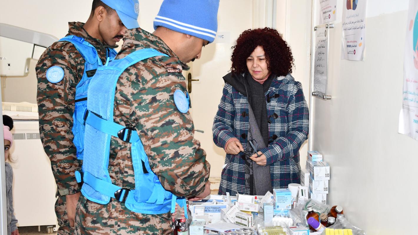 Peacekeepers handing medical supplies to a civilian