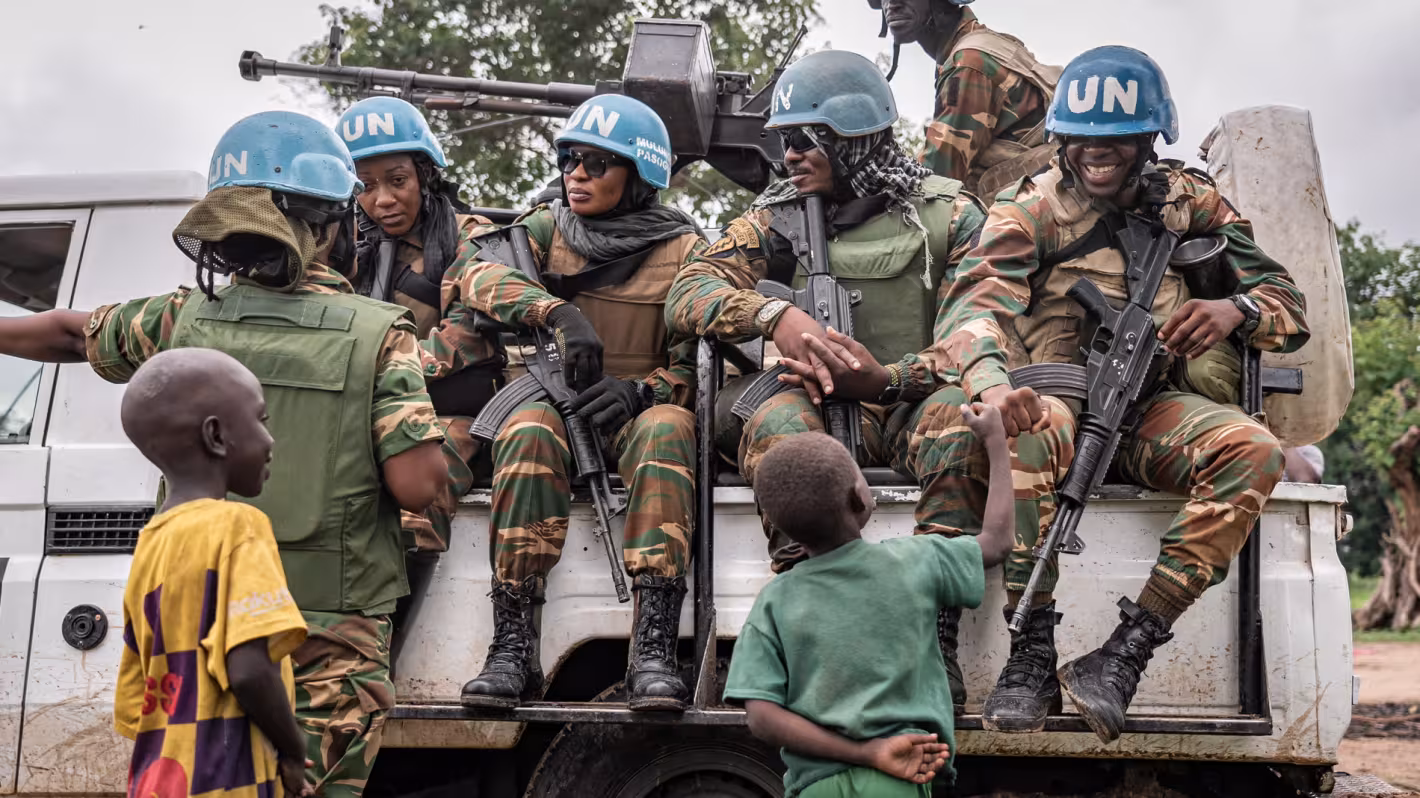 cascos azules, a bordo de un camión de la ONU, interactúan con los niños.