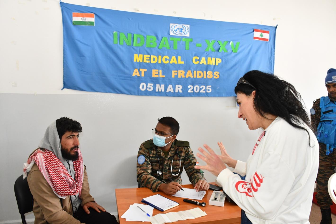 A woman explaining to a patient with a medical peacekeeper sitting next to the patient