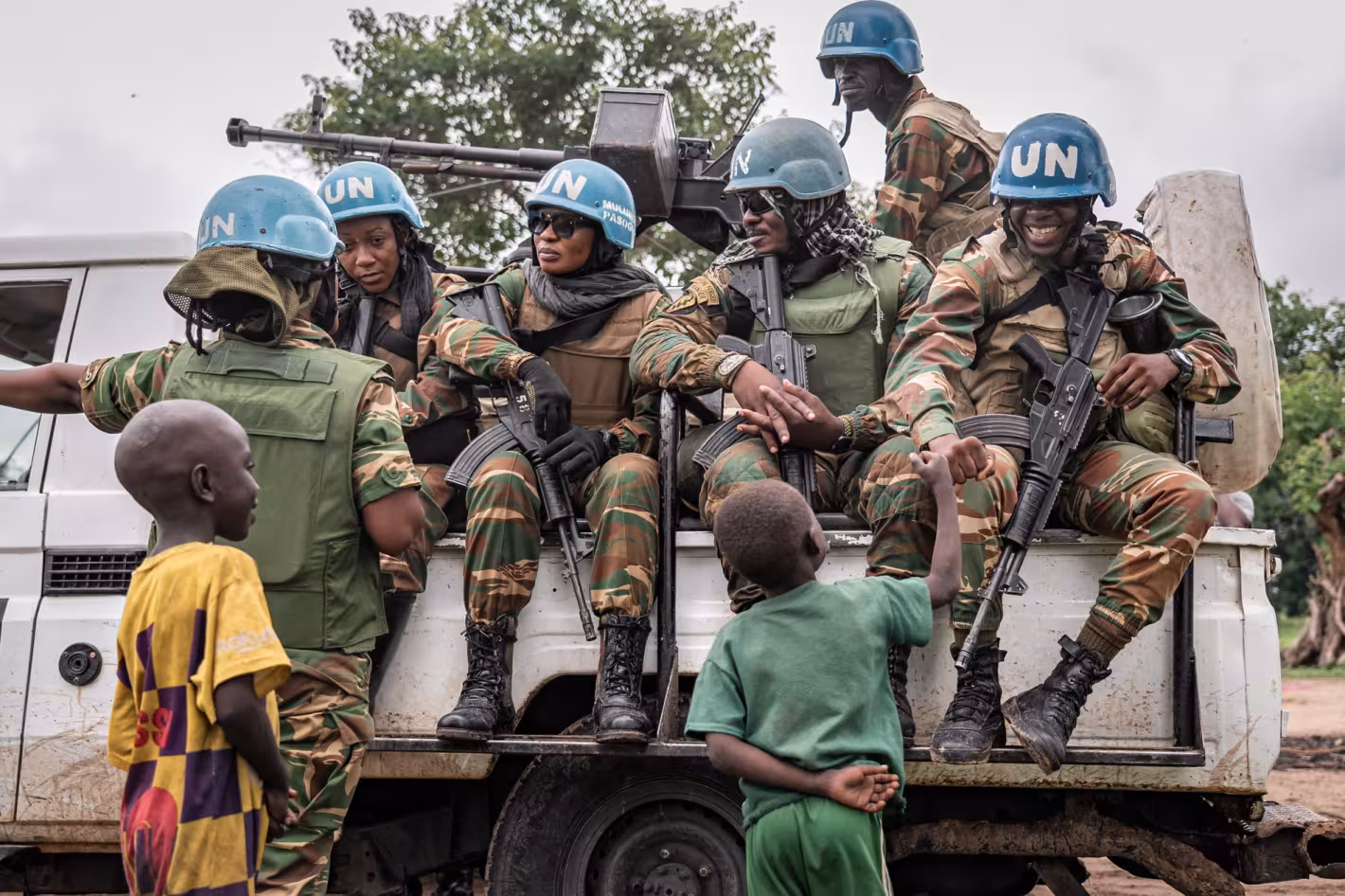 Peacekeepers in a UN truck engage with children.