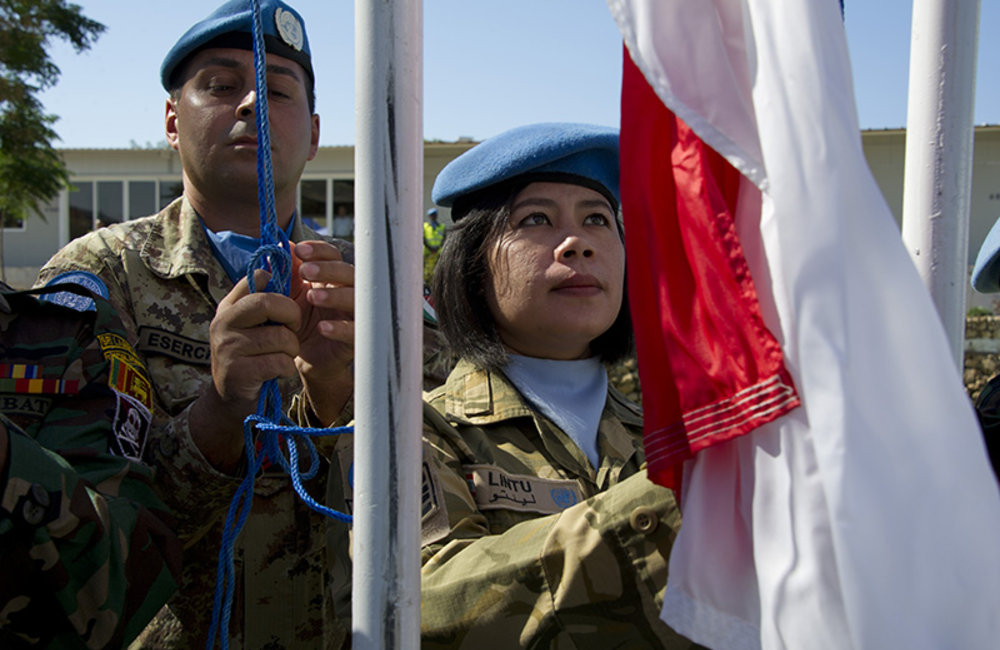 UNIFIL peacekeepers rising troop contributing countries flags during the ceremony to commemorate the 69th anniversary of the United Nations.