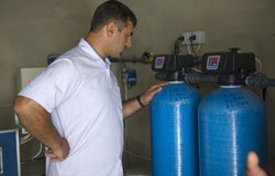 A technician from Tebnin School checking the sand and activated carbo-filter.